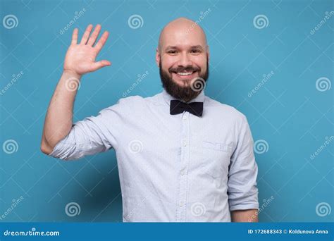 Handsome Bearded Man With Bowtie Saluting Saying Hello Stock Image
