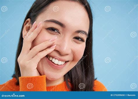 beauty and skincare close up portrait of happy smiling japanese woman touches her clear