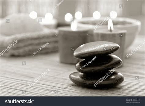 Black Polished Hot Massage Stone Cairn With Burning Candles For A Soothing Spiritual Zen