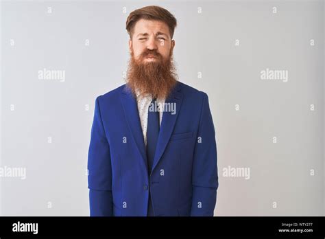 Young Redhead Irish Businessman Wearing Suit Standing Over Isolated White Background Puffing