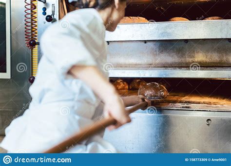 Baker Putting Bread in the Bakery Oven Stock Image - Image of food