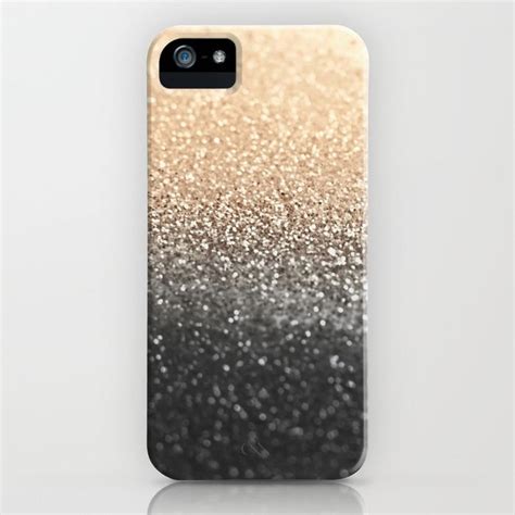 An Iphone Case With Gold And Black Glitters On The Front Sitting On A