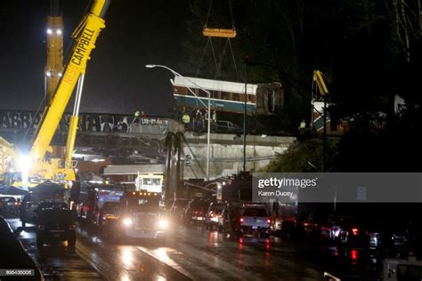 Emergency Crews Continue Lift A Train Car Off The Bridge After An