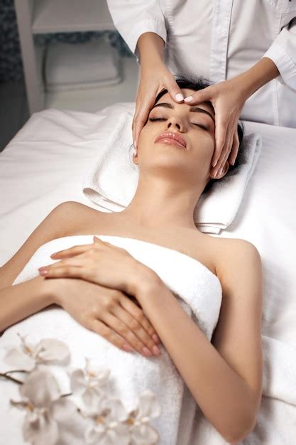 premium photo anti aging facial massage woman receiving massage from masseur at spa salon