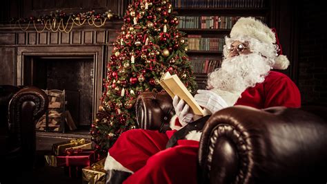 Santa Claus Is Sitting On Sofa And Reading Book Near Christmas Tree Hd