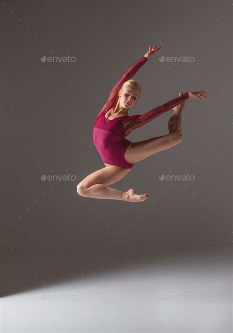 Young Beautiful Modern Style Dancer Jumping On A Studio Background