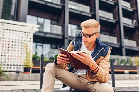 College Student With Backpack Reading Book Chilling By Modern Hotel On