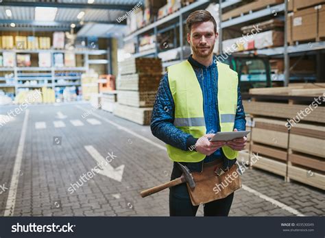 Handsome Young Handyman Or Warehouse Supervisor Standing Amongst The