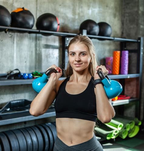 modelo de fitness de belleza ejercicio con pesas rusas en el gimnasio moderno foto premium