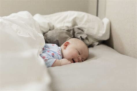 Cute Baby Girl Sleeping On Bed At Home Stock Photo