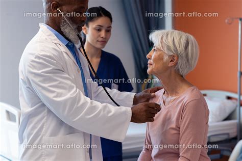 Diverse Senior Male Doctor Using Stethoscope Examining Senior Female