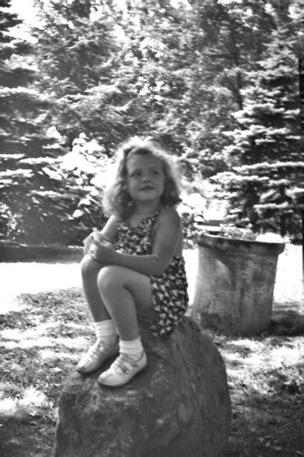 Vintage Photo Negative Of Cute Little Girl In Shorts Sitting On A Rock