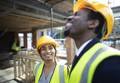 Happy Construction Workers Talking At Construction Site Stock Image