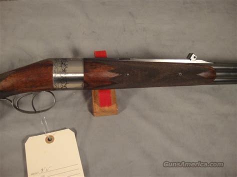 #1066, george hoenig (the maker of the rotary round action revolutionary double rifle), a hoenig total custom 416 rigby rifle on a brevex magnum mauser action, 25 barrel with a 1/4 rib, a hoenig made adjustable standing blade rear sight, barrel band swivel, front ramp with a fold over spring locking sight hood, mounted with detachable rings into tough double shouldered bases, leupold 3x. GEORGE HOENIG ROTARY ROUND ACTION O/U 9.3X74R for sale