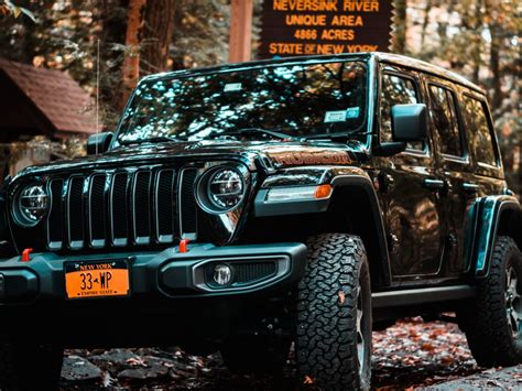 A Jeep Is Parked In Front Of A Sign