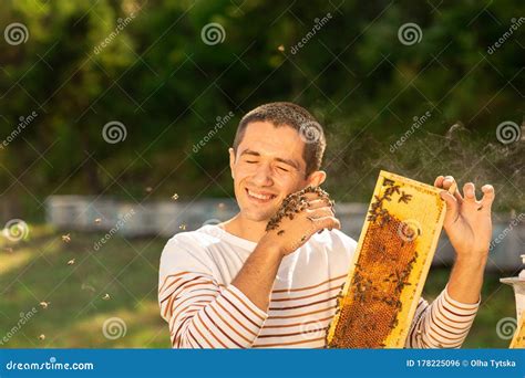 Beekeeper Holding A Honeycomb Full Of Bees A Man Smiling And Gently