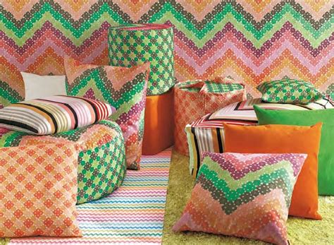 An Assortment Of Colorful Pillows And Blankets In A Room With