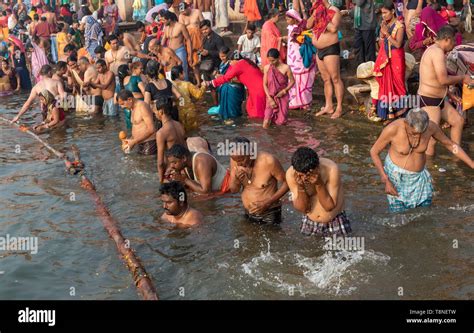 hindu worshippers perform ritual bath and puja prayers in the river ganges varanasi india