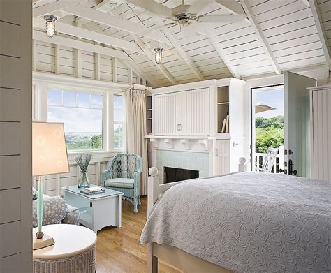 A Bedroom With White Walls And Wood Flooring Has A Bed Chair