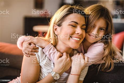 Affectionate Mother And Her Small Daughter Embracing At Home Stock