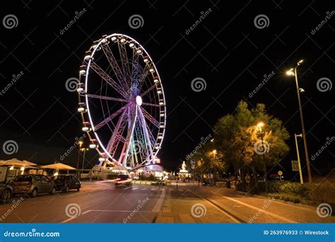 Long Exposure Shot Of A Ferris Wheel At Night With Colorful Lights In