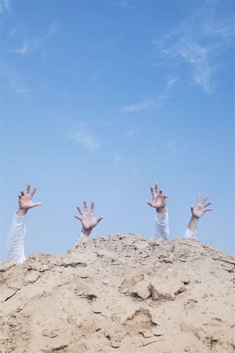 Close Up Of Hands Of Businessmen Behind A Hill In The Desert Reaching