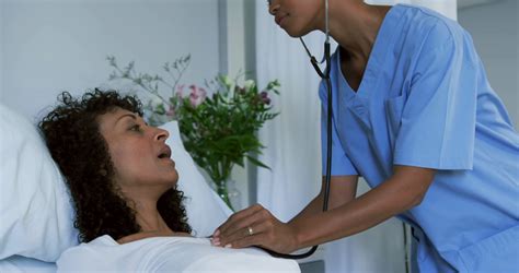Close Up Of African American Female Doctor Examining Female Patient In