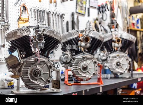 Three Vintage Harley Davidson Engines On Display In A Garage Stock