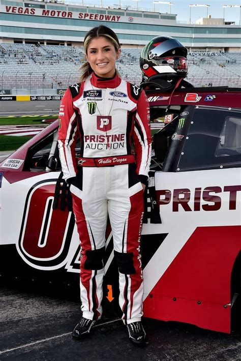 A Woman Standing In Front Of A Race Car