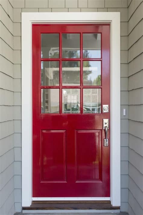 A Red Front Door With Two Sidelights And Glass Panels On The Top Part Of It