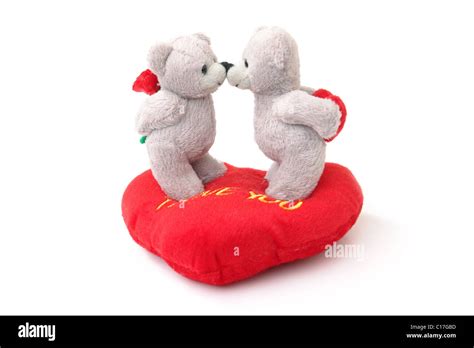 Two Stuffed Teddy Bears Kissing Each Other On Stuffed Heart Shaped