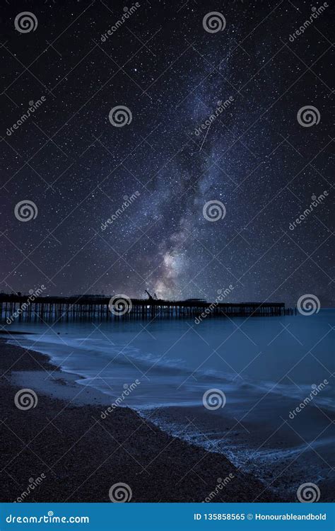 Vibrant Milky Way Composite Image Over Landscape Of Low Tide Harbour