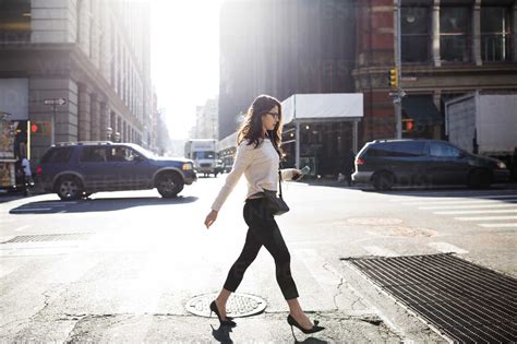 Full Length Of Young Woman Walking On City Street Stock Photo