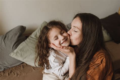 A Mother Kissing Her Daughter On The Cheek · Free Stock Photo