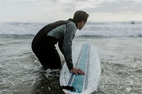 Premium Photo Man At The Beach With His Surfboard