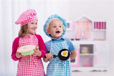Niños Jugando Con Cocina De Juguete Fotografía De Stock © Famveldman