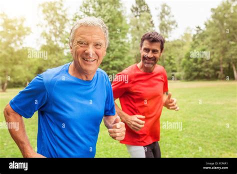 Two Men Running Outdoors Smiling Stock Photo Alamy