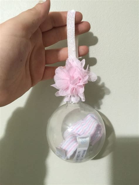 Baby Hat And Hospital Wristbands In A Clear Ornament With A Newborn