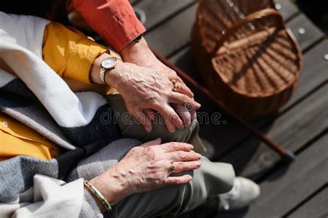 Top View Of Seniors Holding Hands Having Romantic Moment During Autumn