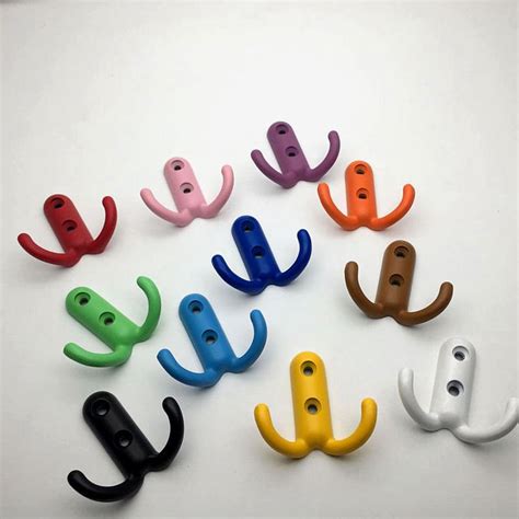 There Are Many Different Colors Of Hooks On The White Surface With