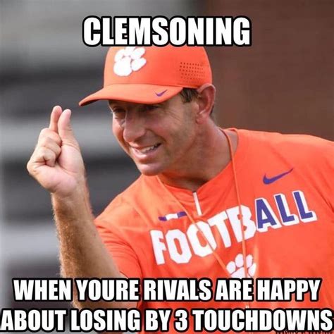 A Man In An Orange Baseball Uniform Giving The Peace Sign With His Hand And Saying Clemson