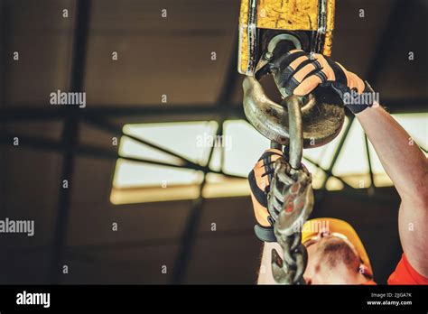 Closeup of Caucasian Contractor Attaching Something to the Lifting Hook