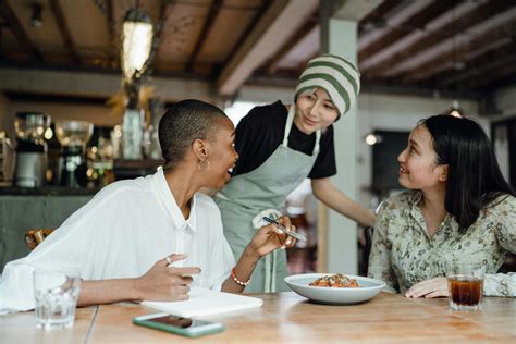 Cheerful colleagues tasting food in cafeteria · Free Stock Photo