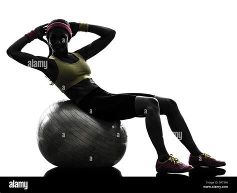 One Woman Exercising Crunches Workout On Fitness Ball In Silhouette On