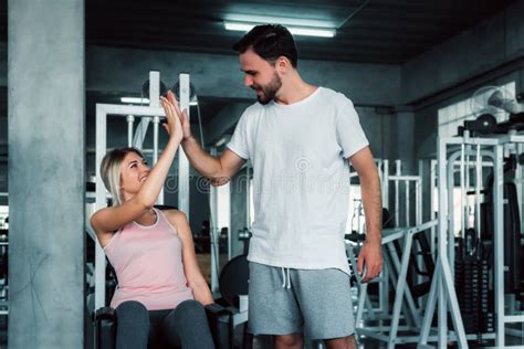 attractive fitness couple love giving high five together after workout in fitness gym portrait