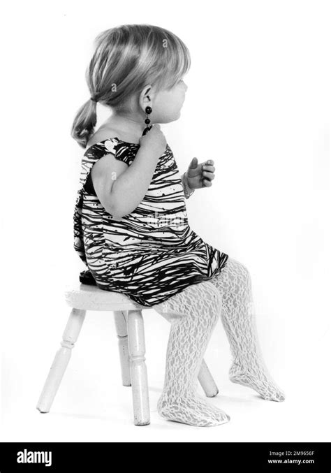 A Little Girl Sitting On A Stool Stock Photo Alamy