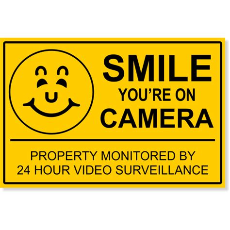 This security camera video surveillance warning sign is 10 1/2 inches wide by 8 inches high and is made of 0.19 aluminum. 12" x 18" Smile You're On Camera Sign - CustomSigns.com