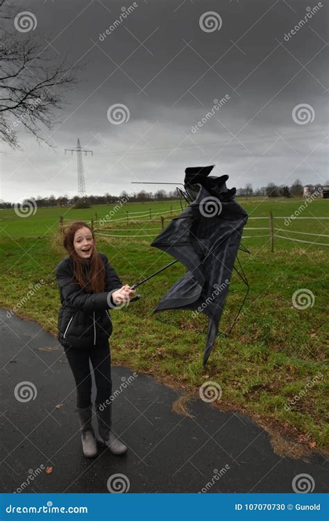 Girl Walks Through The Storm Her Umbrella Is Broken Stock Photo