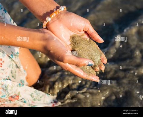 Girl Holding Wet Beach Sand Stock Photo Alamy