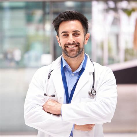 Portrait Of Male Doctor With Stethoscope Wearing White Coat Standing In